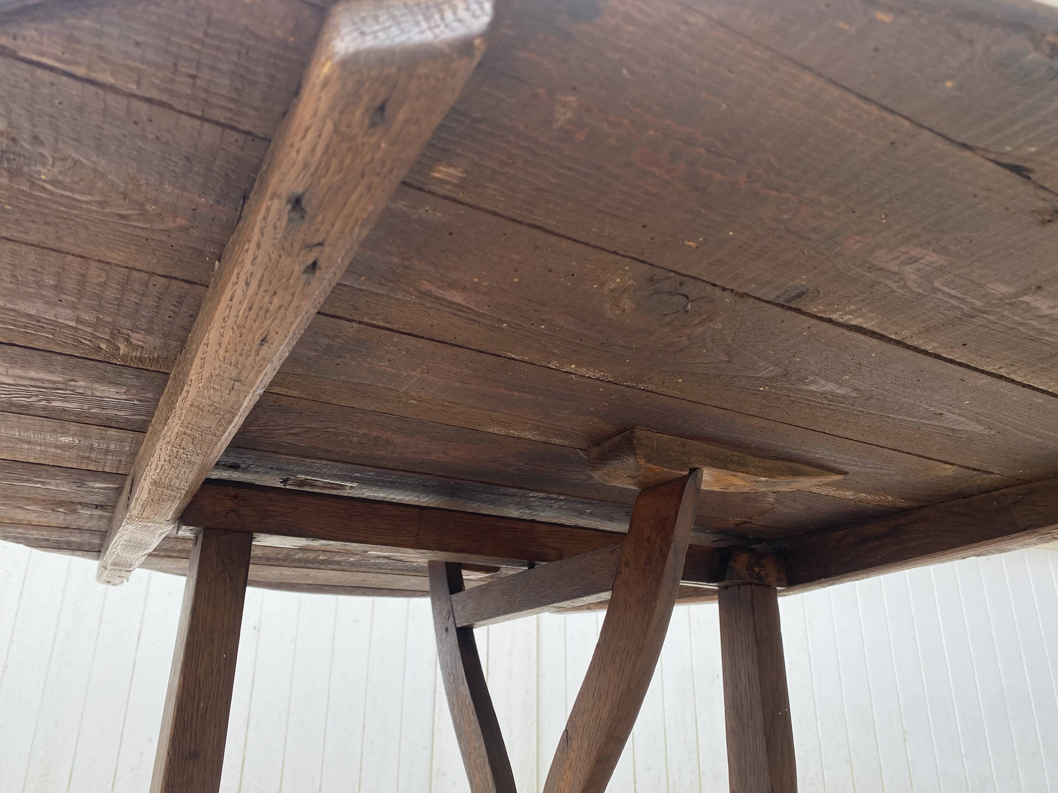 Old folding round winemaker's table with a tilting top.