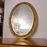 Beveled oval mirror in gilded wood 78×58cm