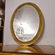 Beveled oval mirror in gilded wood 78×58cm
