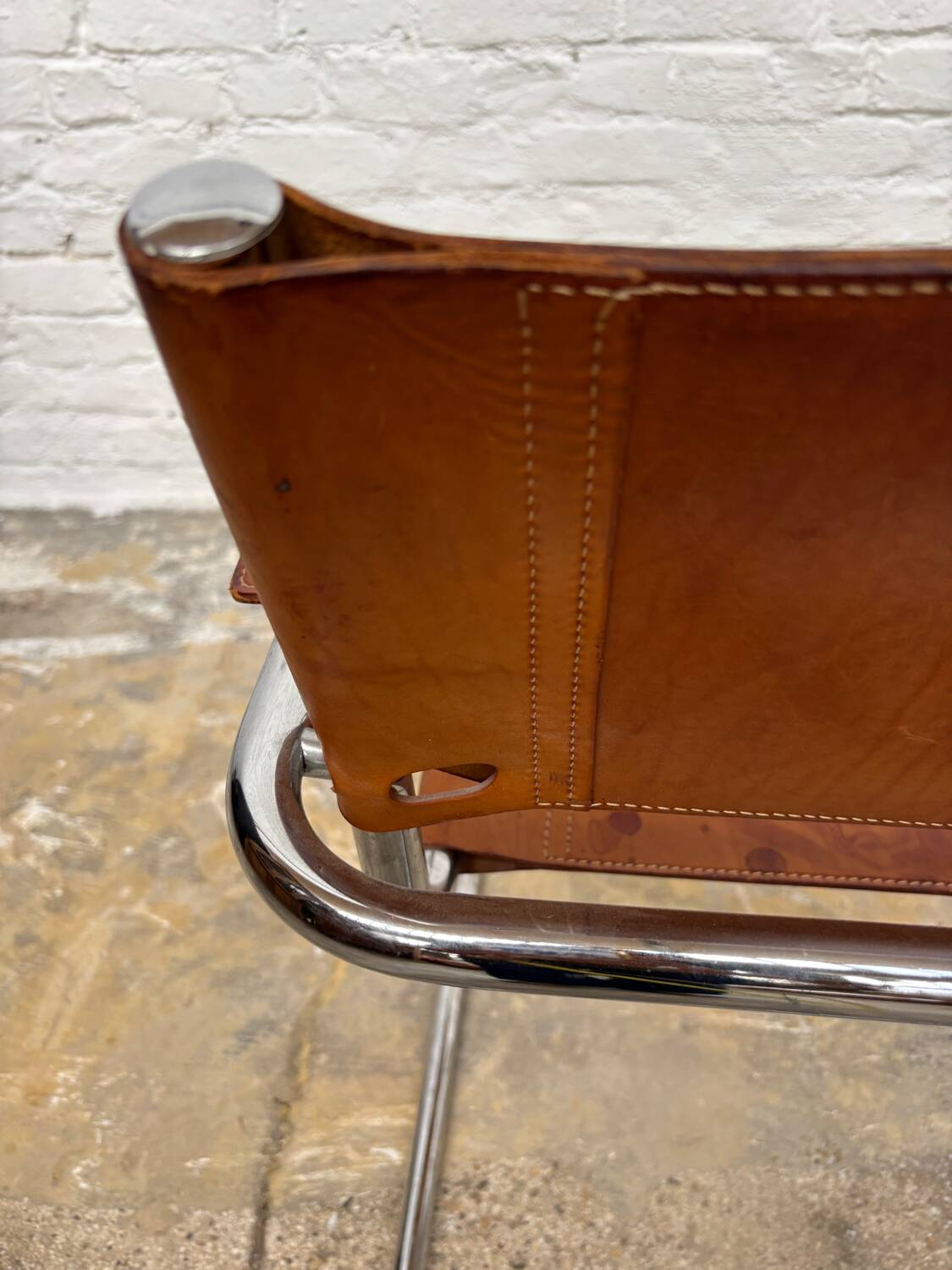 Vintage aluminum tube and tan leather armchair