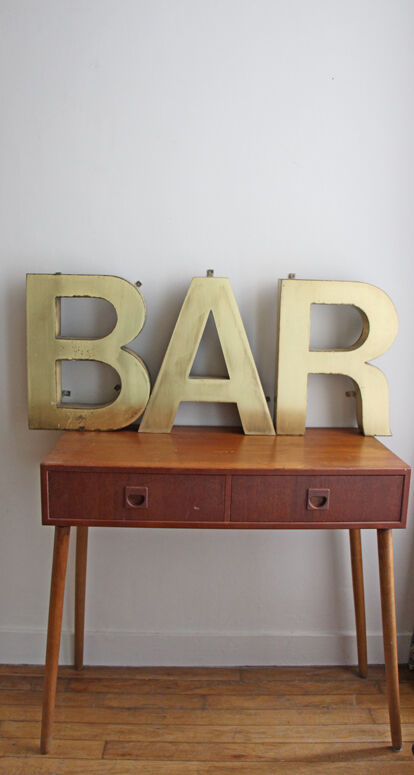 Old brass sign letters, word BAR