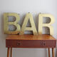 Old brass sign letters, word BAR