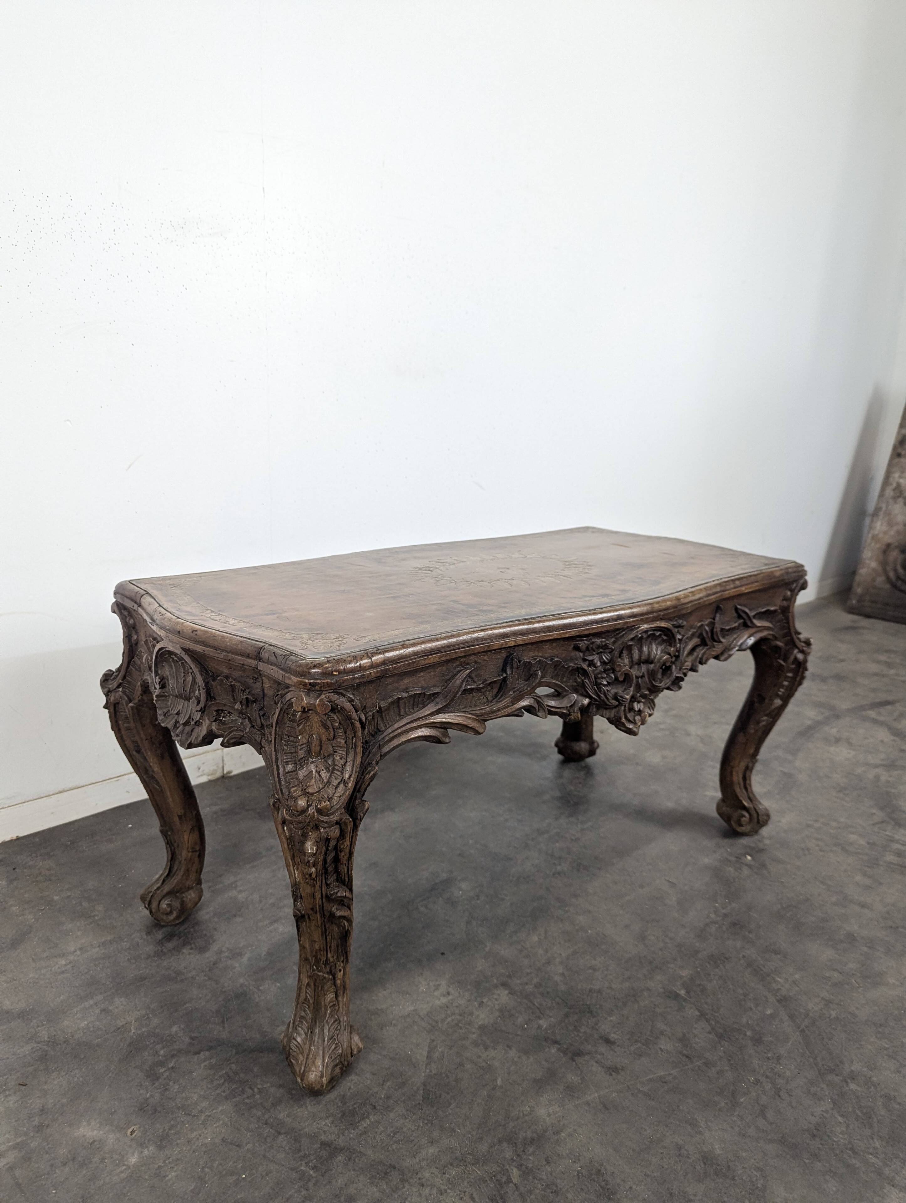 Louis XV coffee table in carved walnut with a gilded leather top.