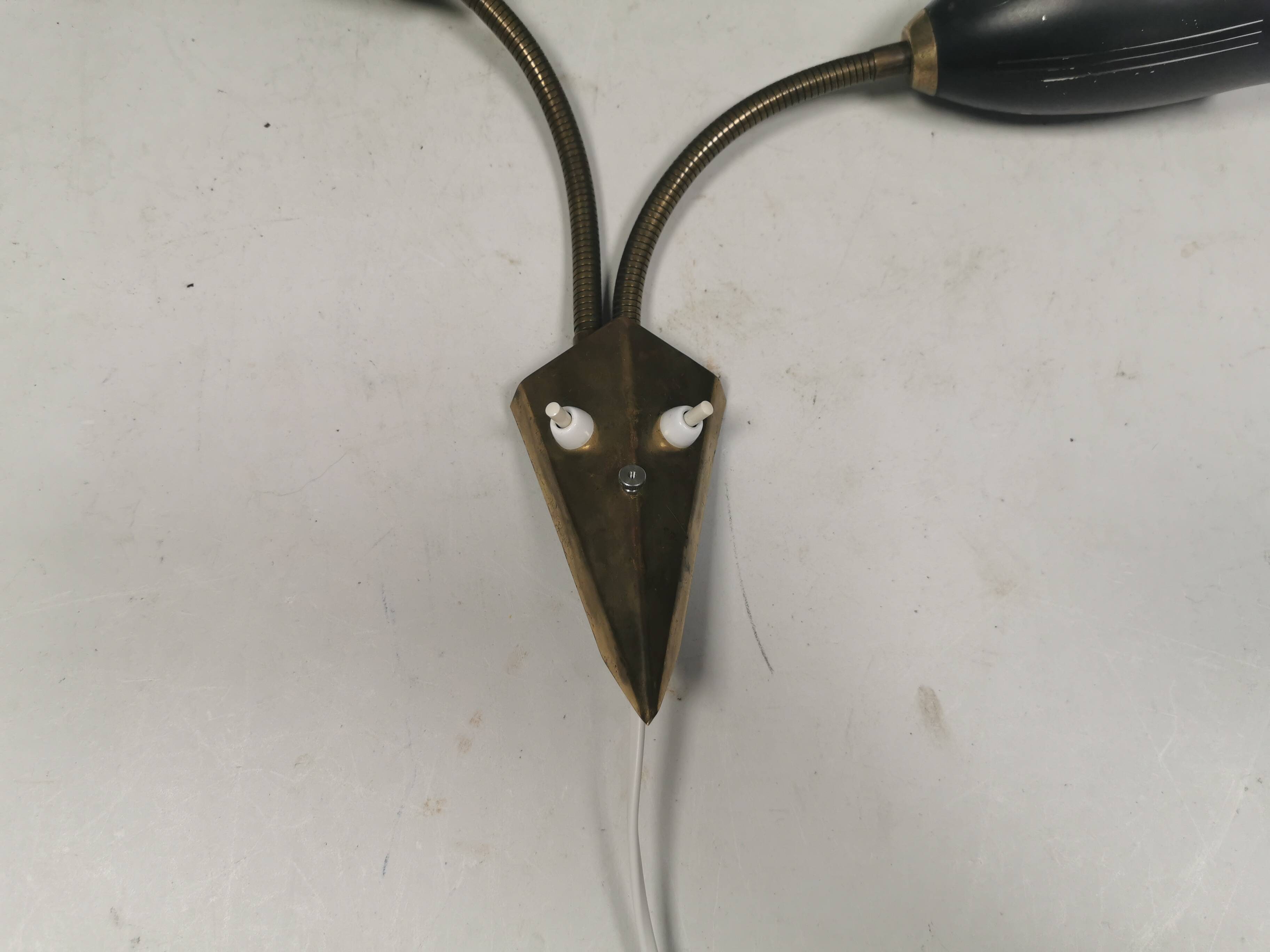 Older wall lamp with black metal shades and brass bend ‘arms’