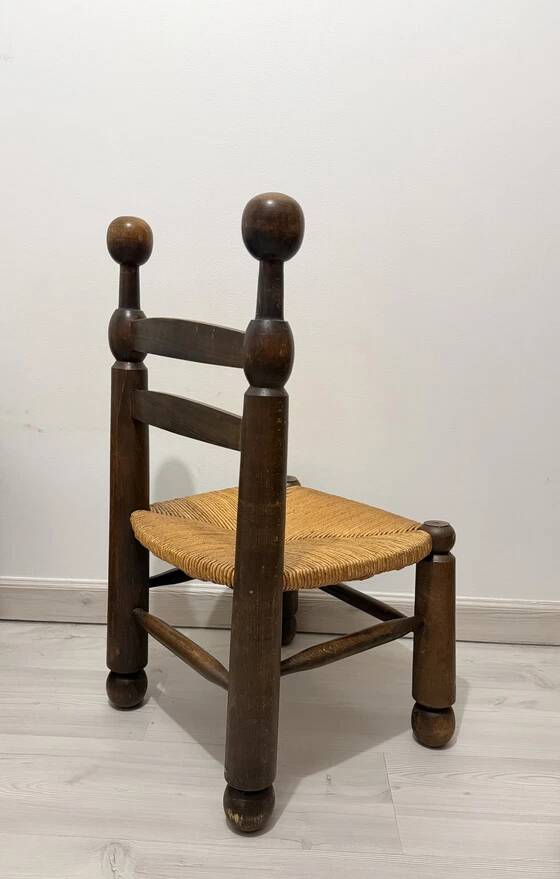 Low fireplace chair in the style of Charles Dudouyt – wood and straw seat.