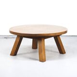 Large rustic vintage coffee table in a round brutalist style.