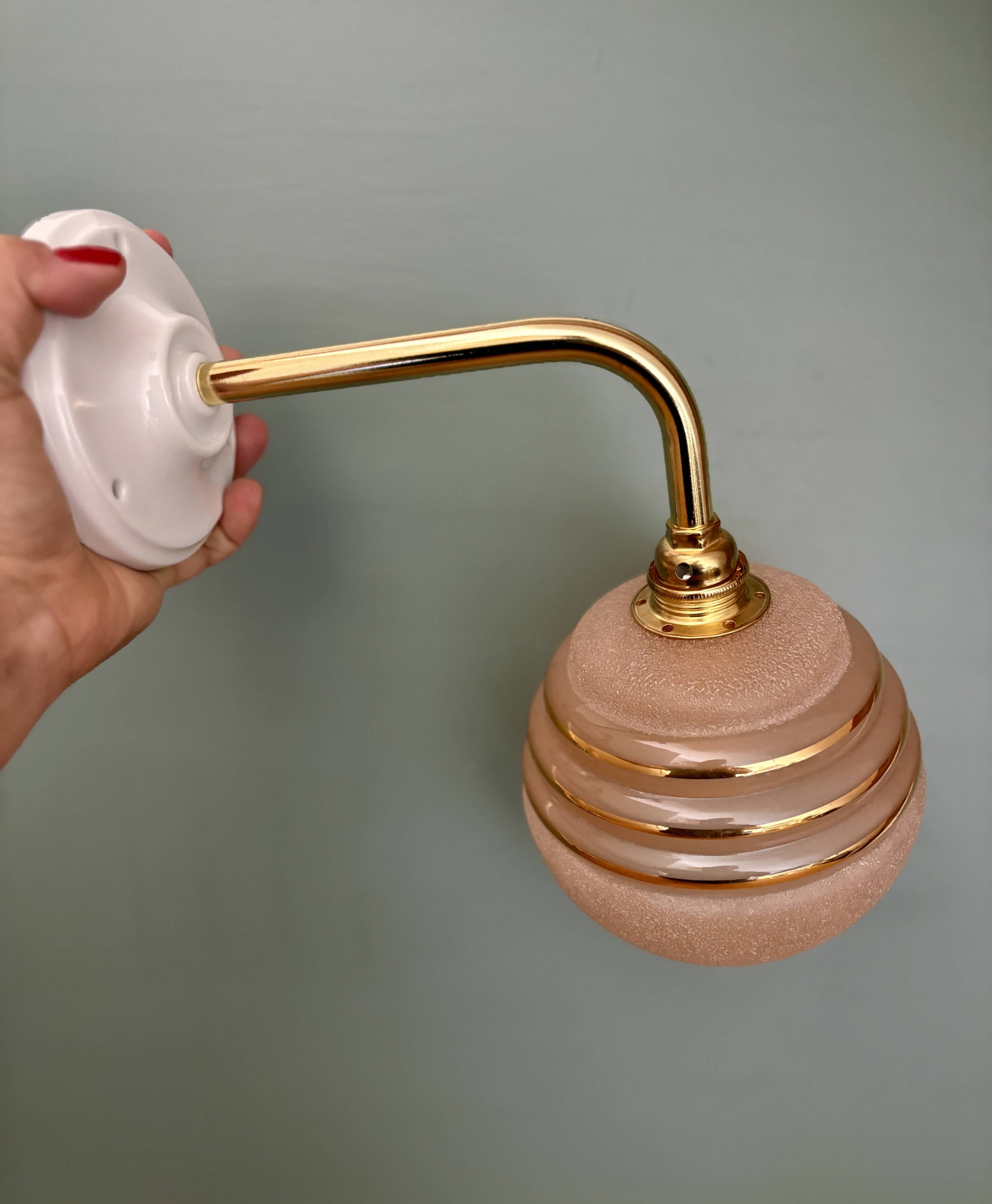 Vintage pink and gold frosted glass globe wall light.