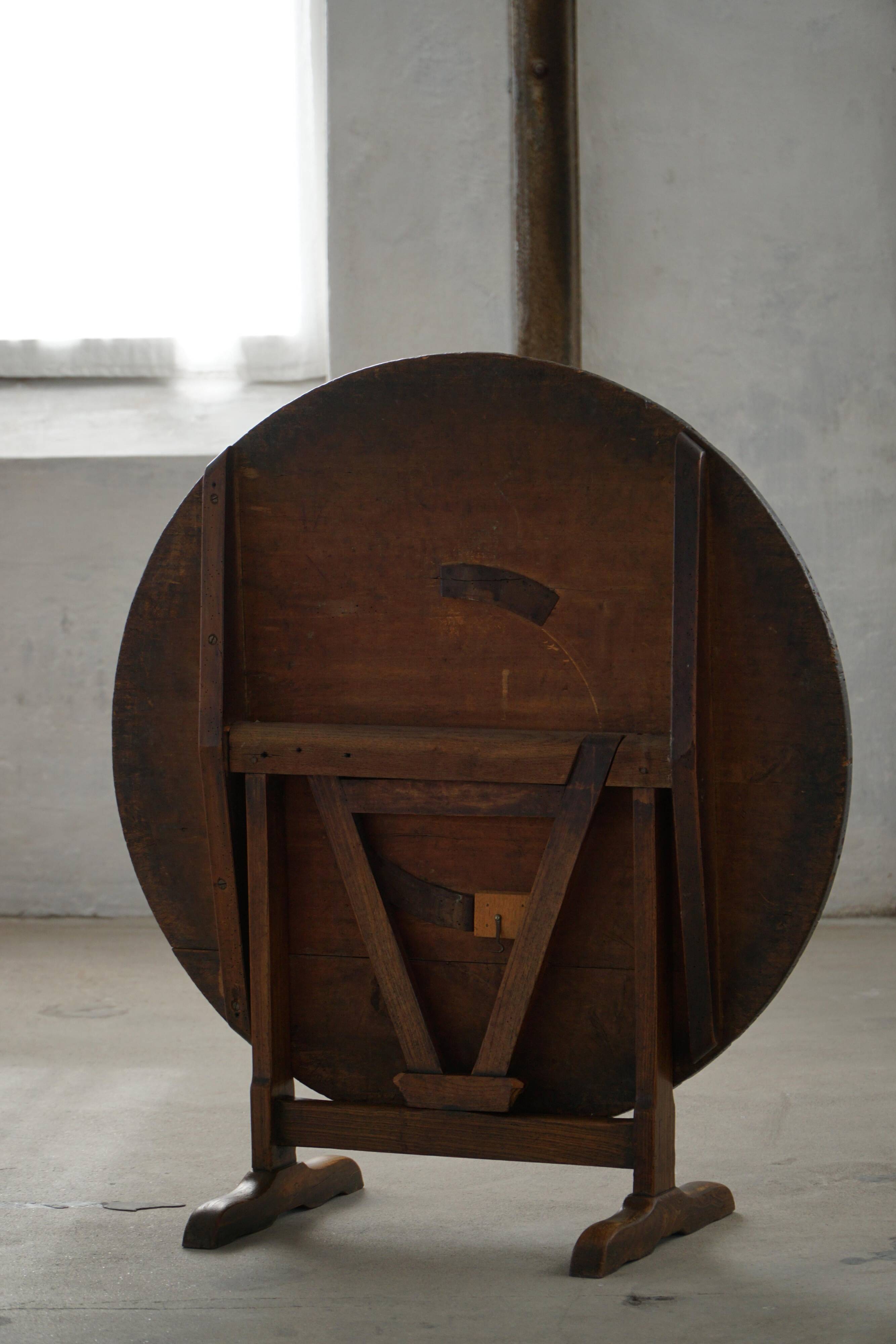 Round table with a tilting top from a 19th-century provincial French winemaker in oak.