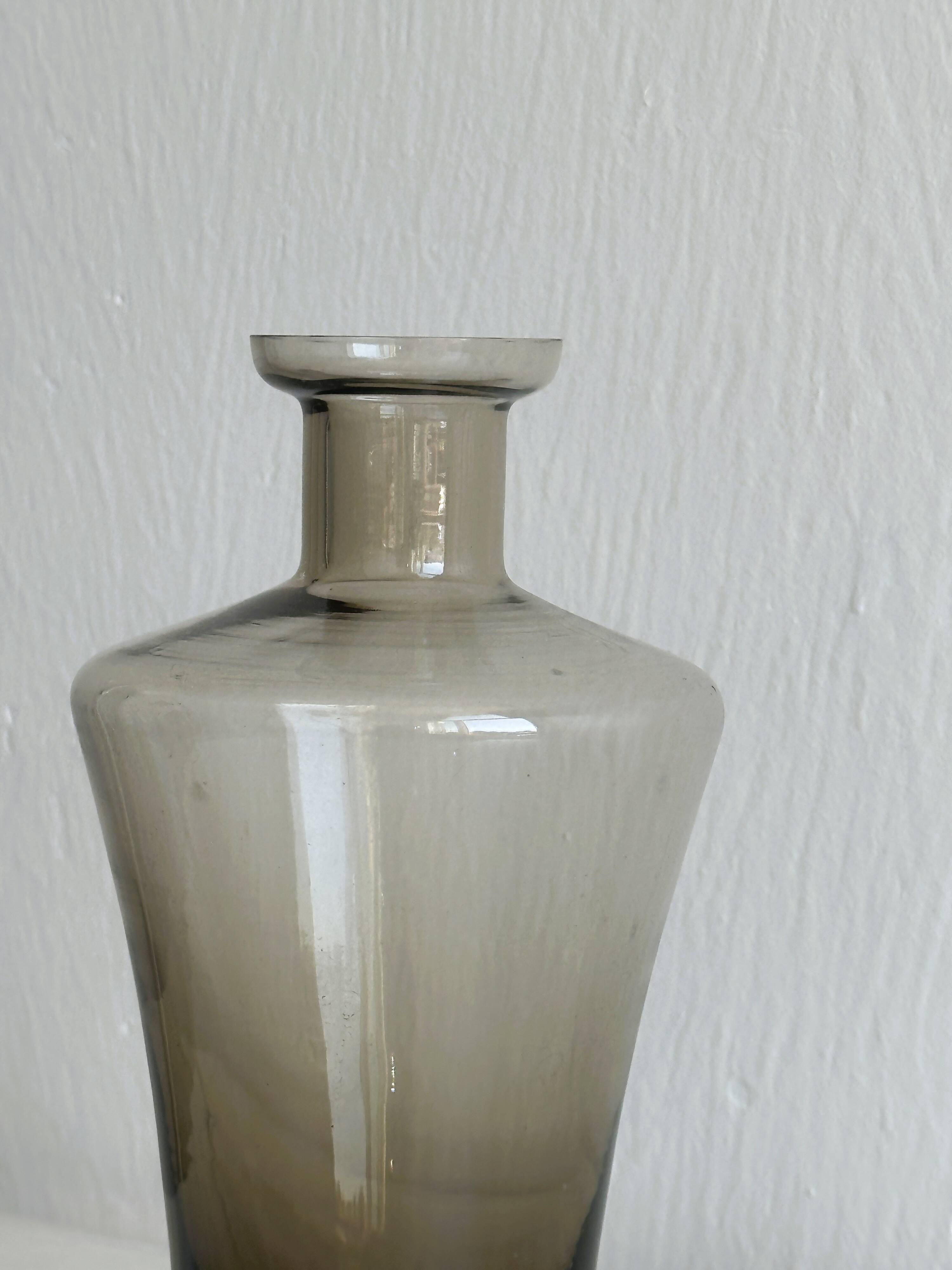 Carafe, old smoked glass bottle with sculpted stopper.