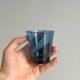 Four small translucent blue glasses.