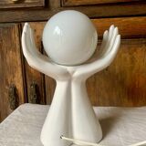 Ceramic table lamp depicting two hands holding a globe, 1980