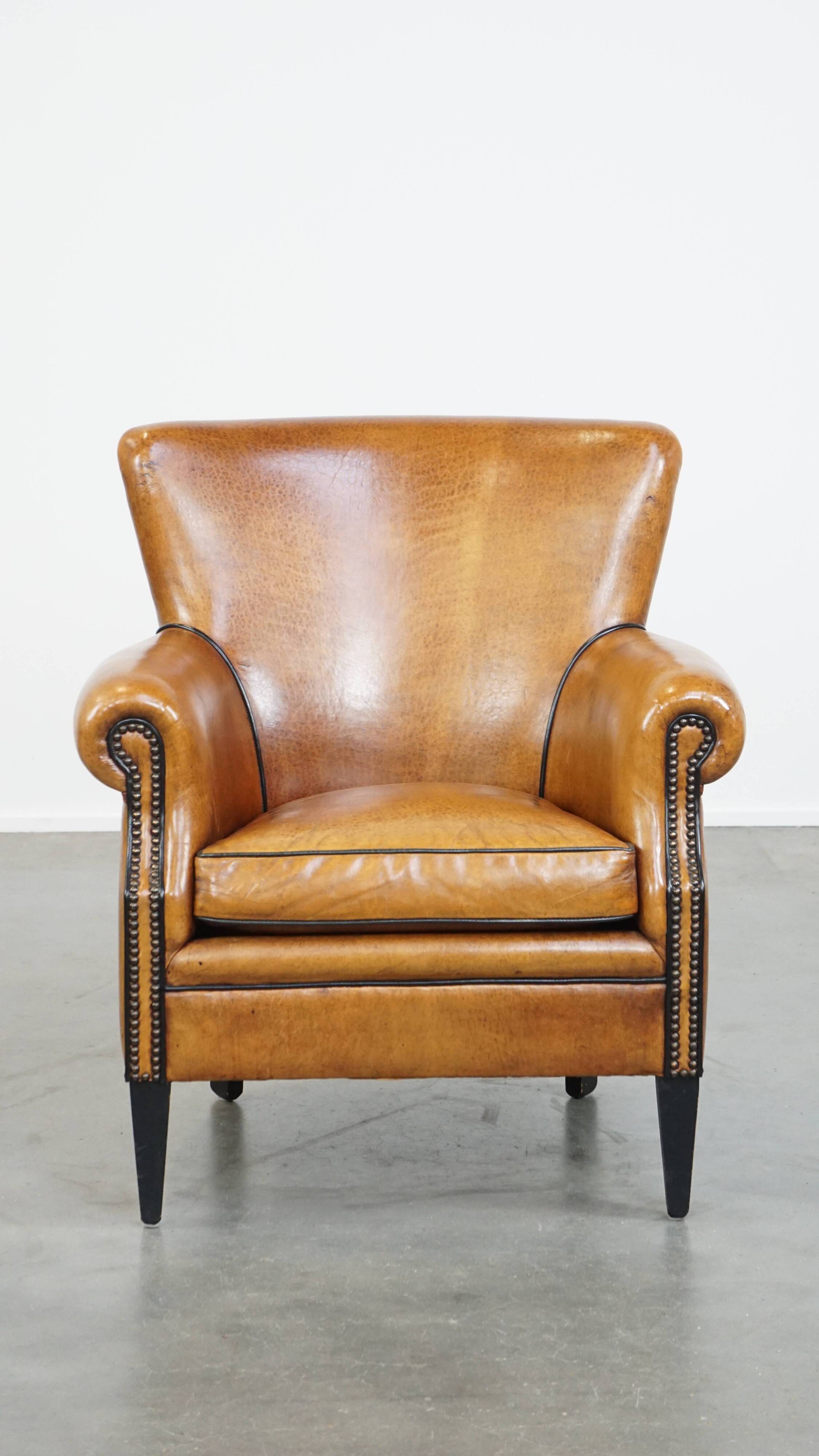 Cognac-colored sheep leather armchair finished with decorative nails