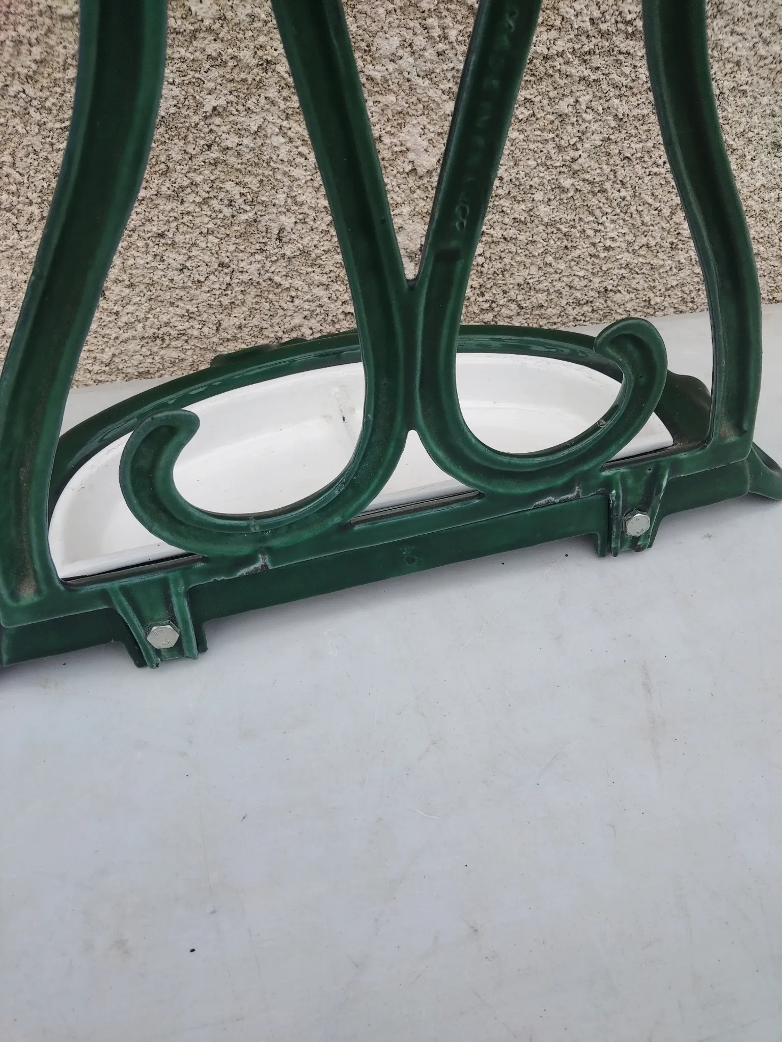 Bottle green enamelled cast iron umbrella stand with a swirl design.