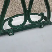 Bottle green enamelled cast iron umbrella stand with a swirl design.