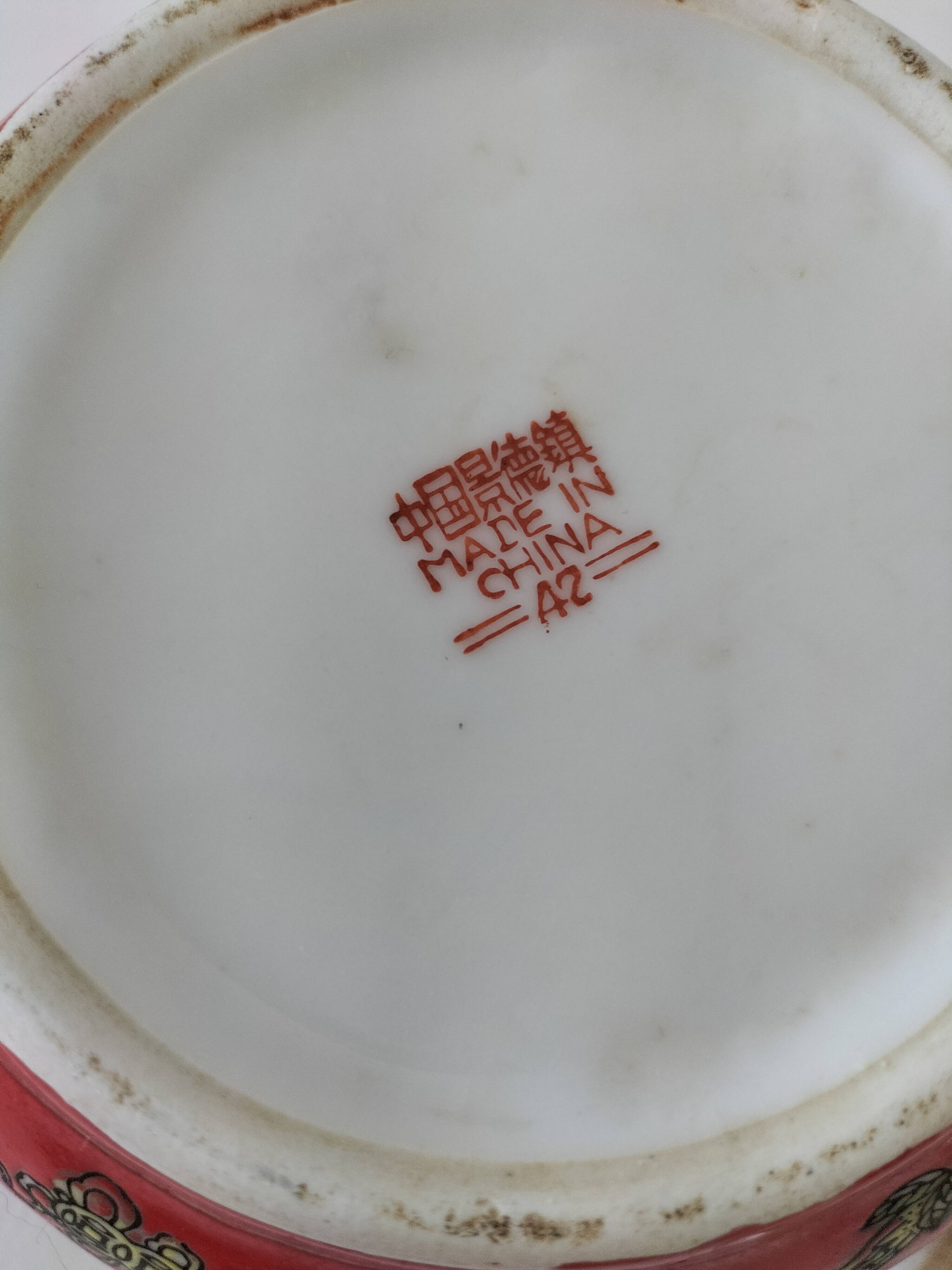 Vintage red Chinese teapot decorated with dragons and symbols.
