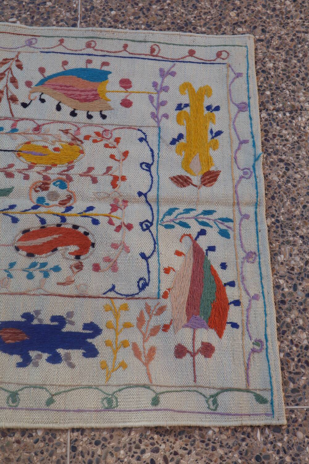 White suzani kilim rug with embroidered colorful patterns