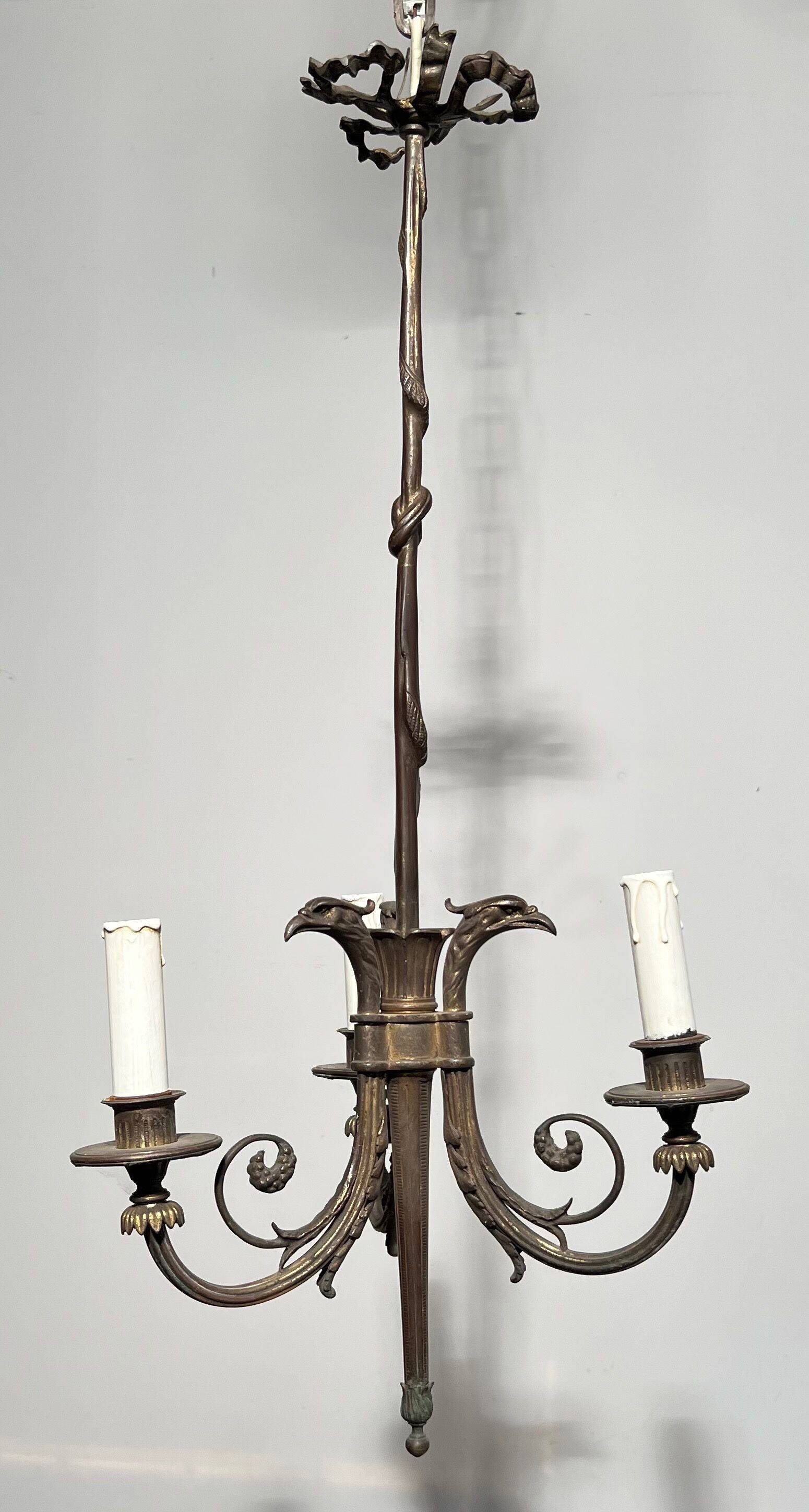 Empire-style bronze chandelier with 3 arms of light topped with eagle heads. French work. Circa 1900.
