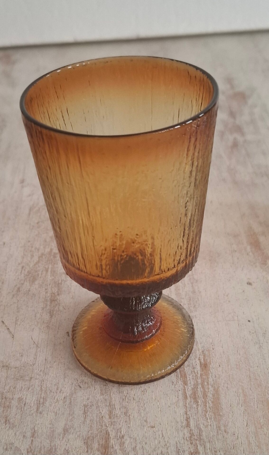 Set of four thick amber glass stemmed glasses.