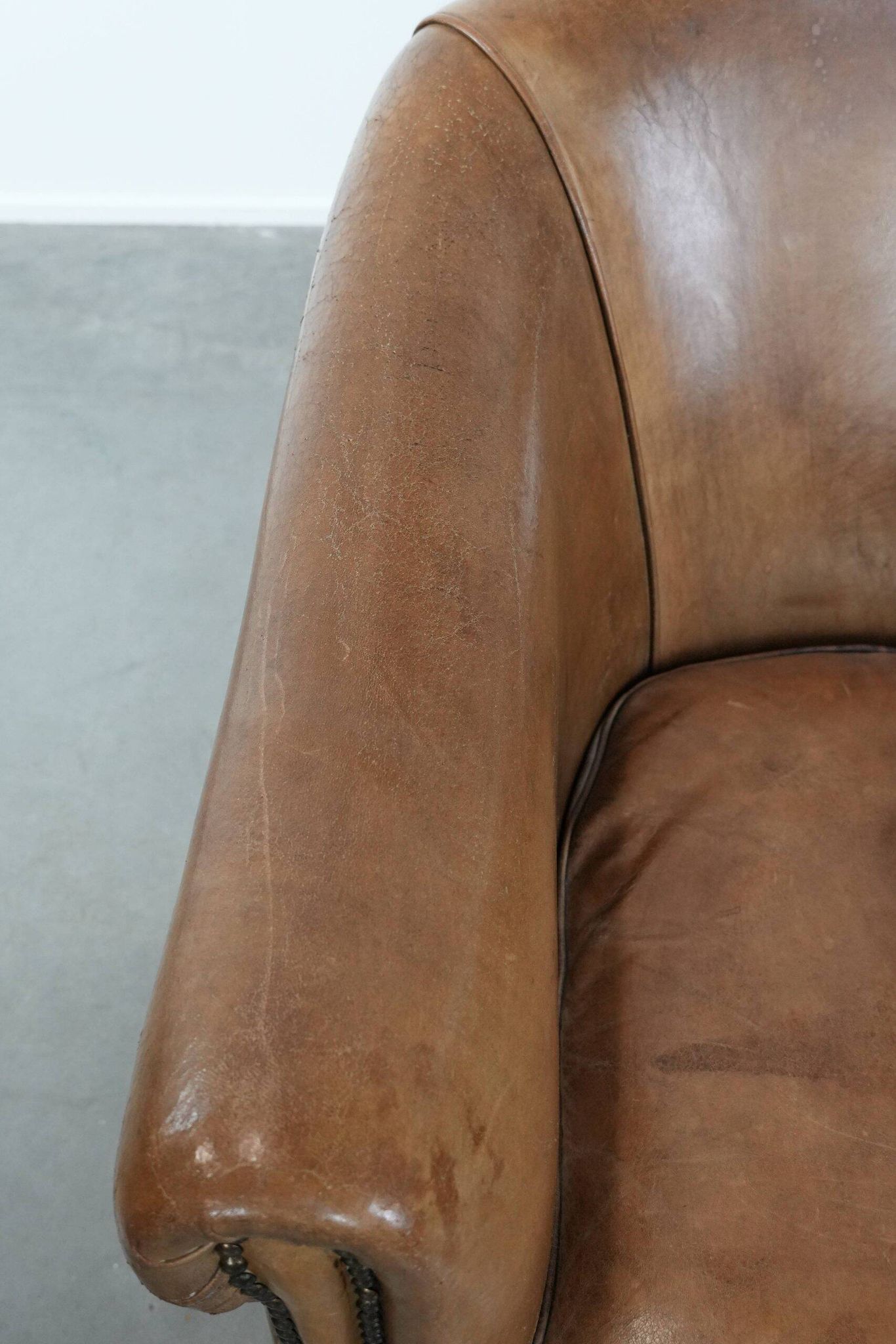 Characterful club chair made of sheepskin leather with light cognac colours