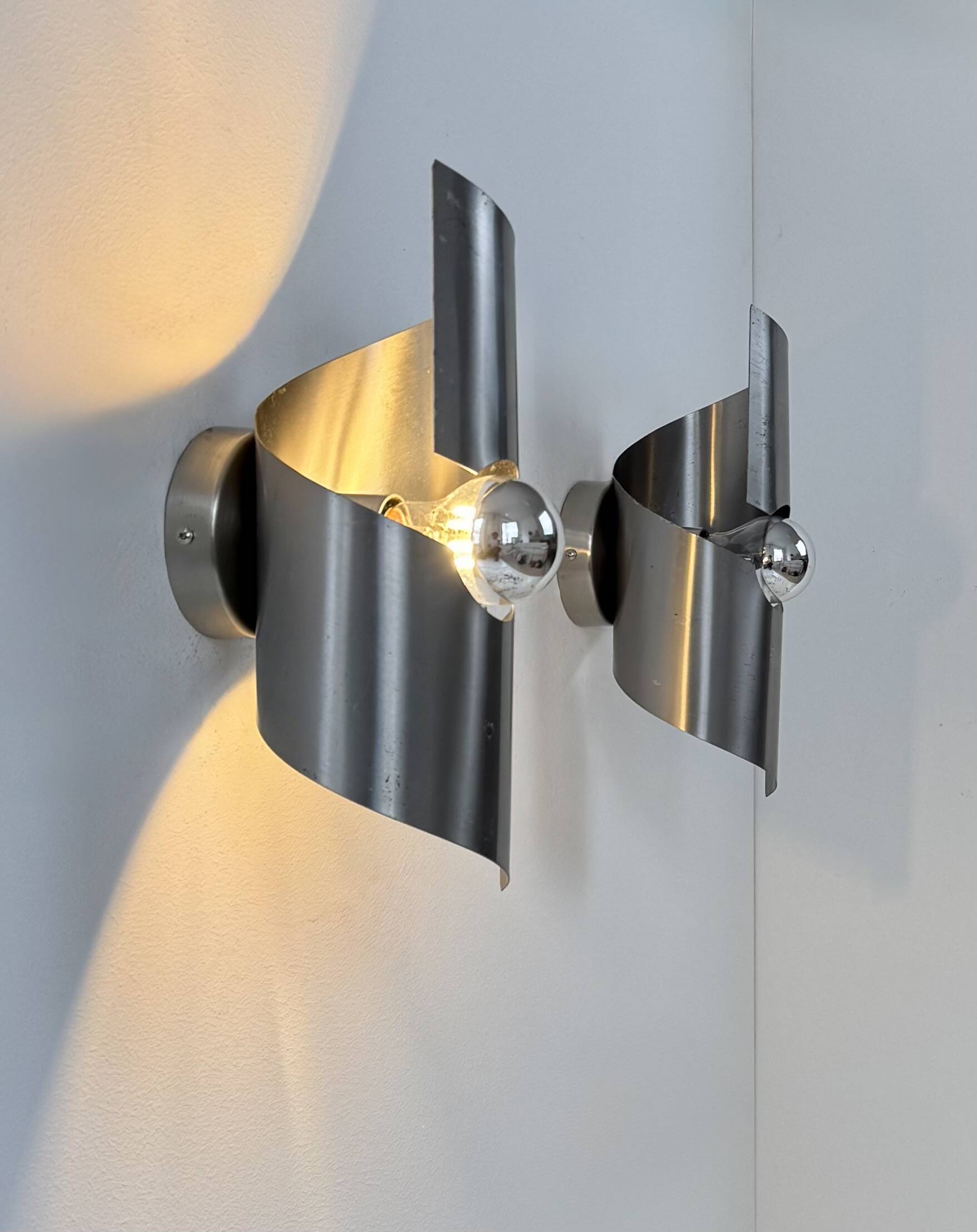 Pair of vintage wall lights, curved patinated steel, France, 1970.