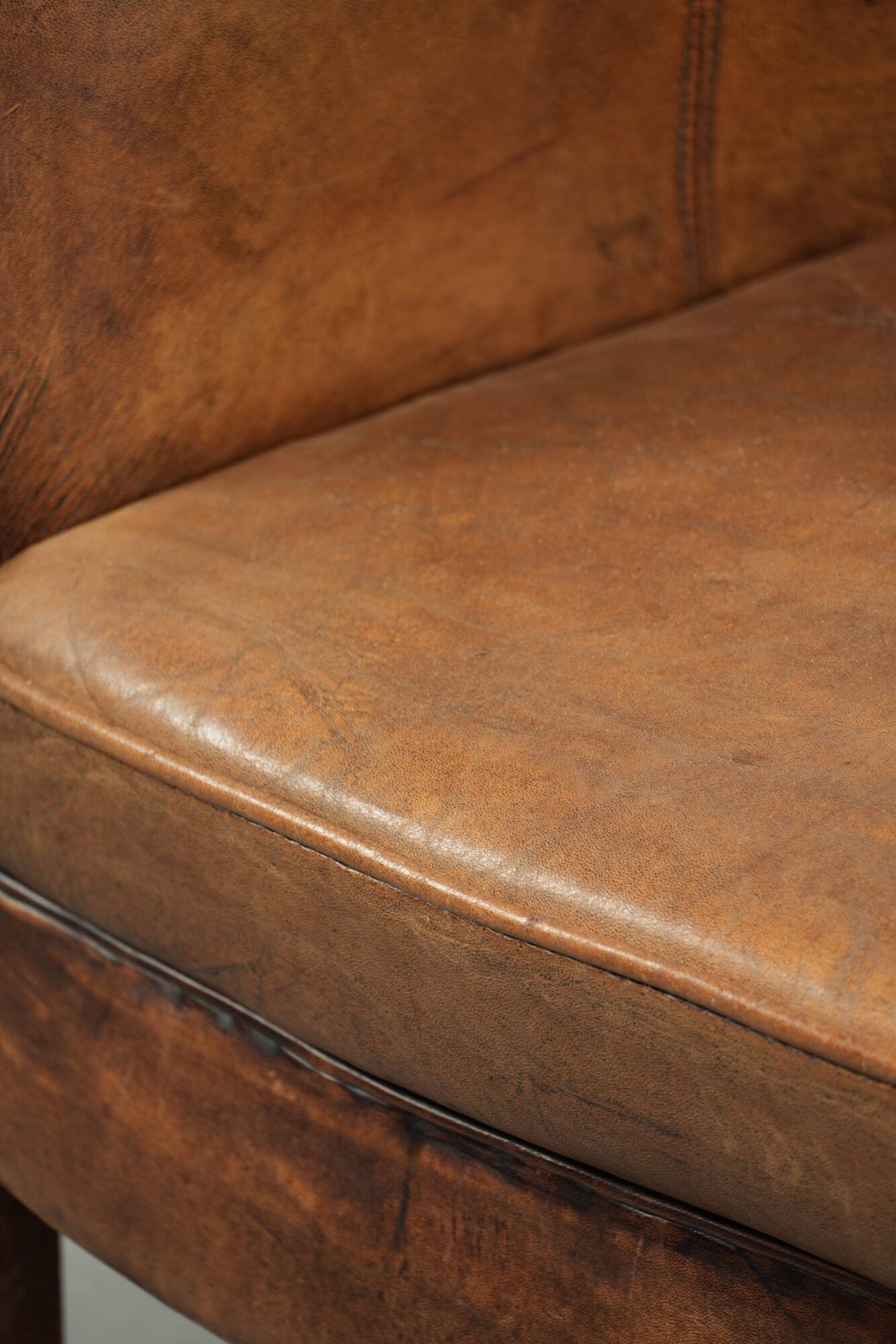 Sheepskin club armchair in a brown colour finished with decorative nails