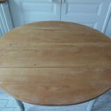 Walnut table with raised flaps, base on verdigris casters.