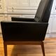 Modernist armchair in wood and black synthetic leather, circa 1960