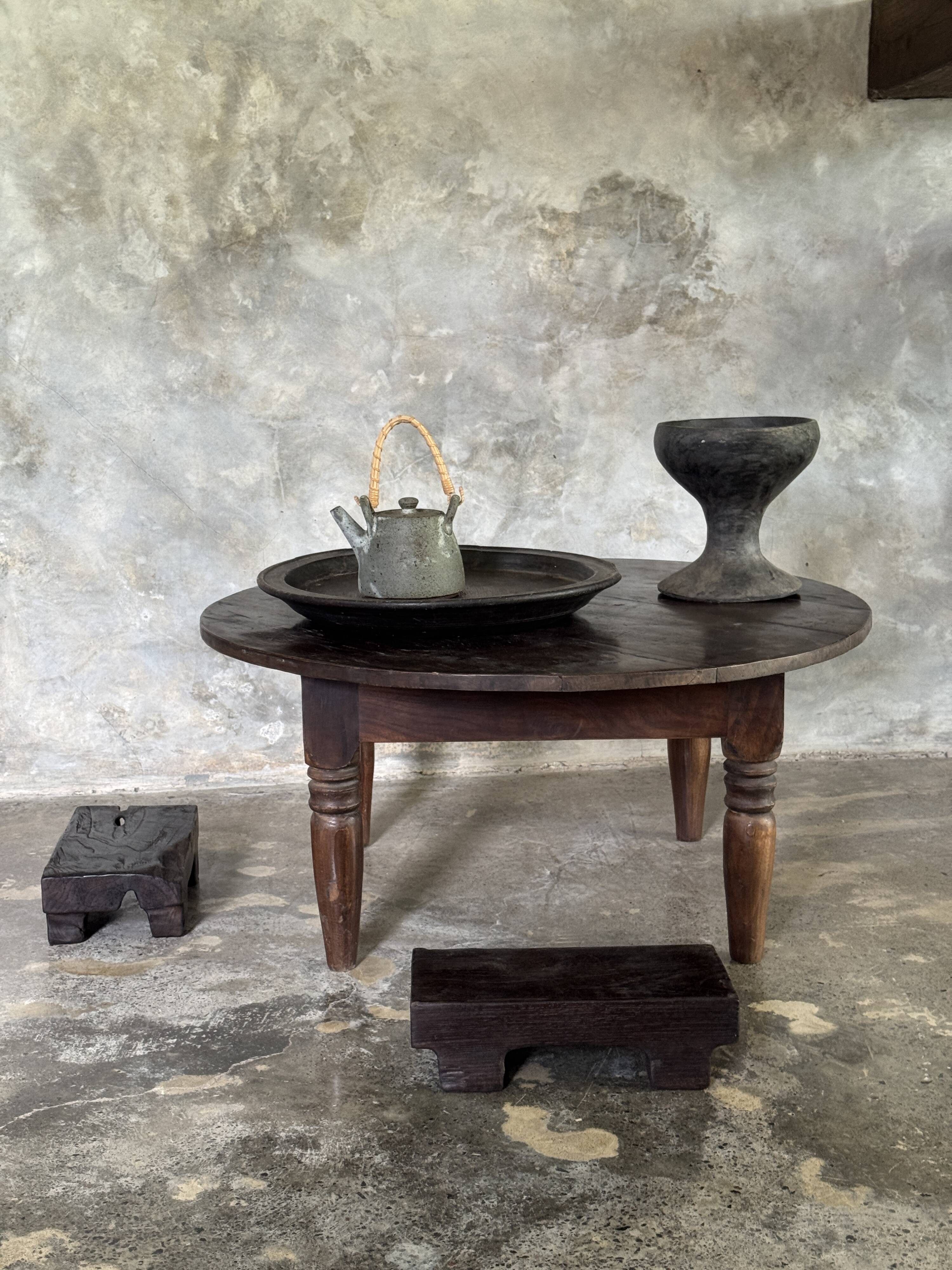 Coffee table, round antique Indonesian teak table with straight legs.