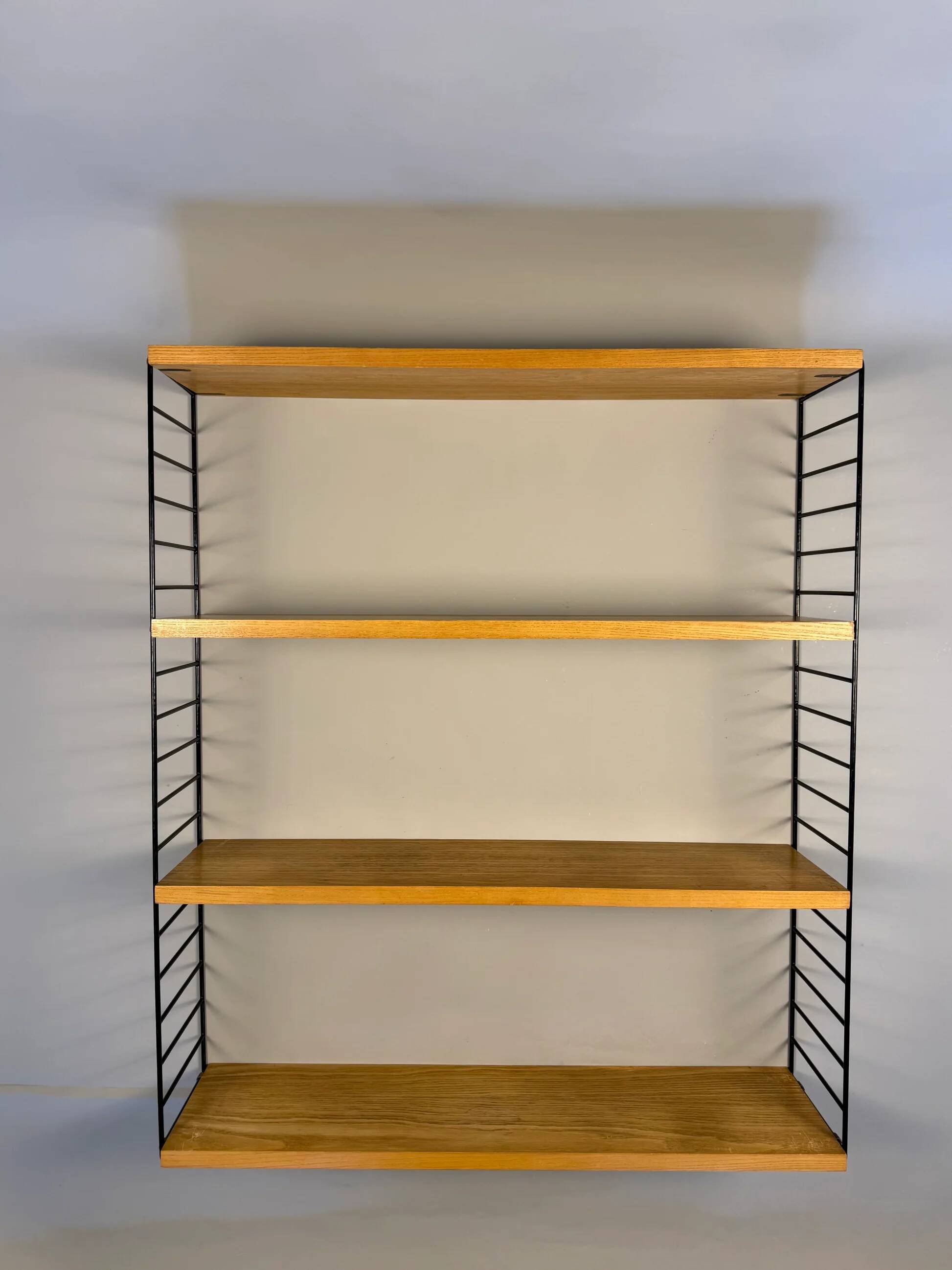 Floating wall shelf in oak veneer and black metal, 1960s.