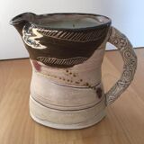 Signed ceramic pitcher. Glazed part. Worked cove