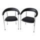 Set of two metal chairs with a brushed finish and black leather.