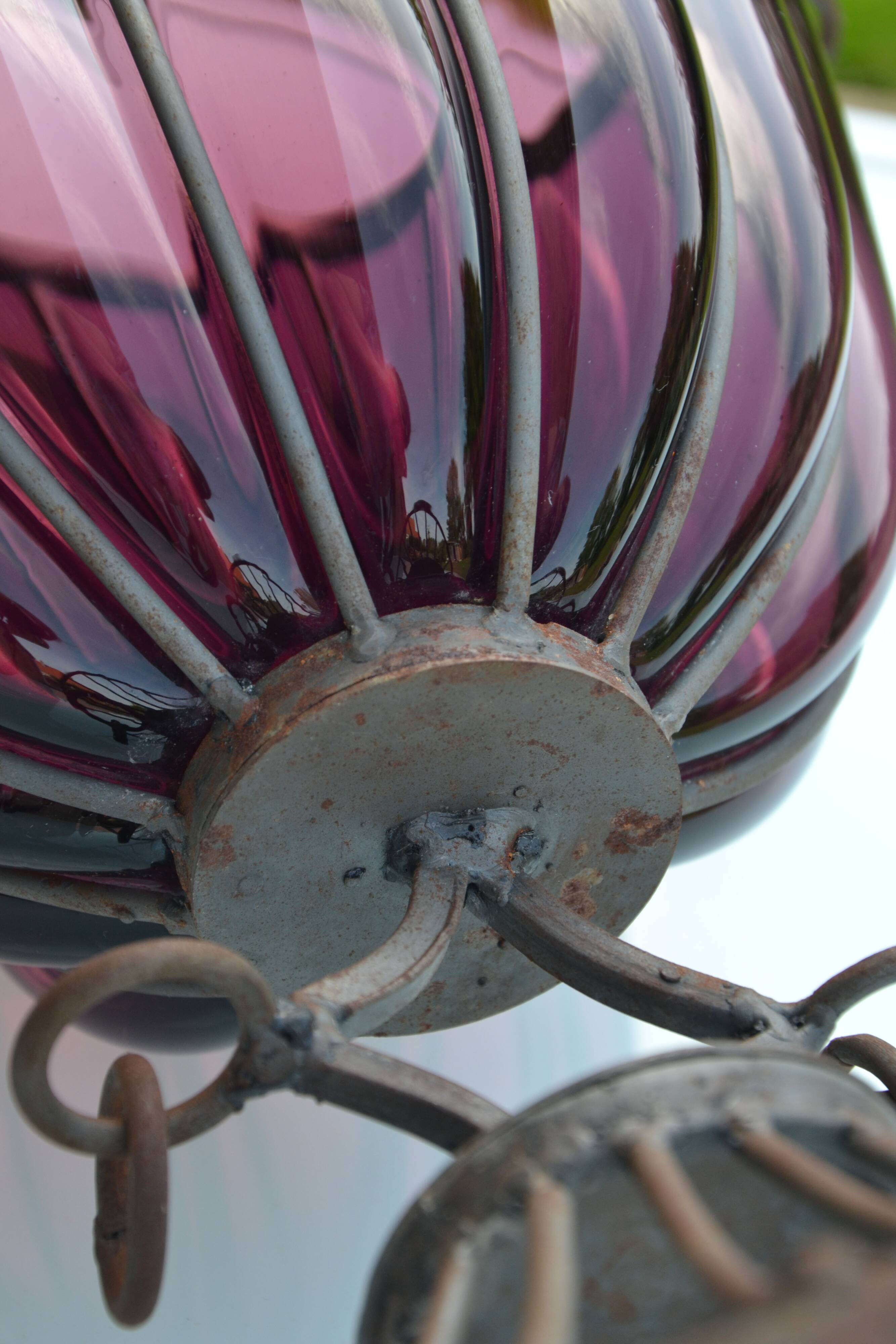 Large blown glass and wrought iron vase on shower stand