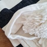 Hand-woven plaid with black stripes and white pompoms