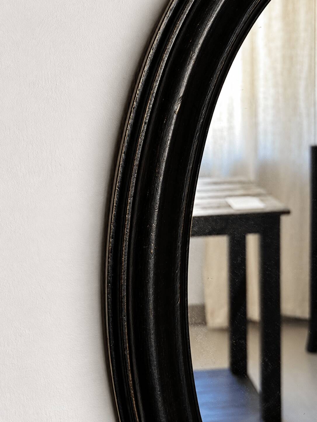Antique oval mirror in patinated black wood