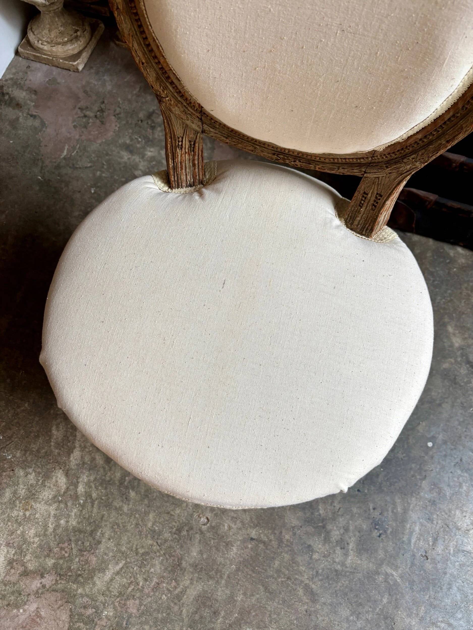 Medallion back chair in moulded wood and beige fabric.