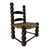 Brutalist wood turned bobbin low rush chair n the style of Charles Dudouyt
