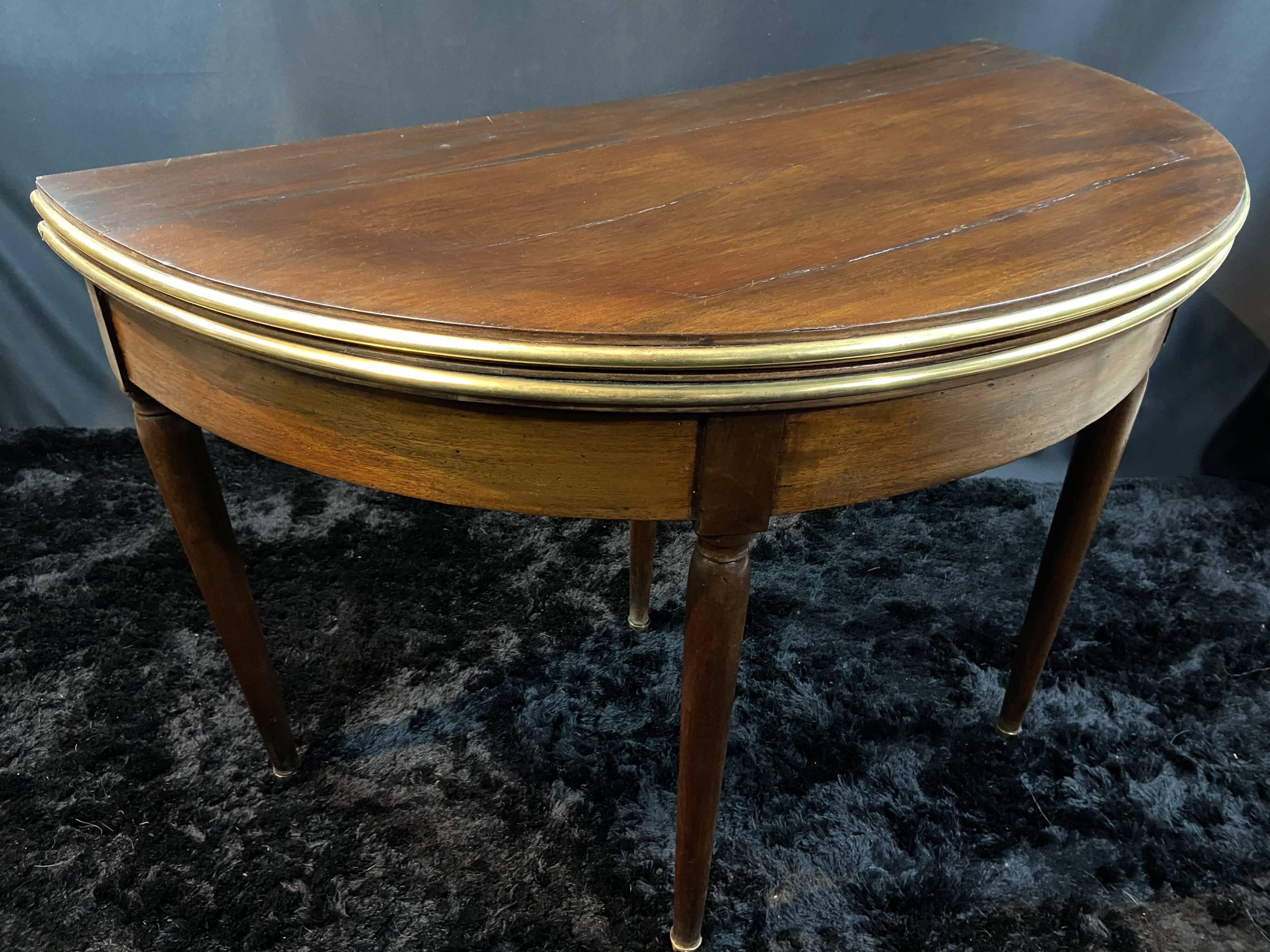 A Louis XVI period mahogany half-moon table forming a console/games table