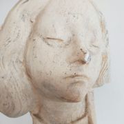 Bust of woman in plaster on pedestal with inscription