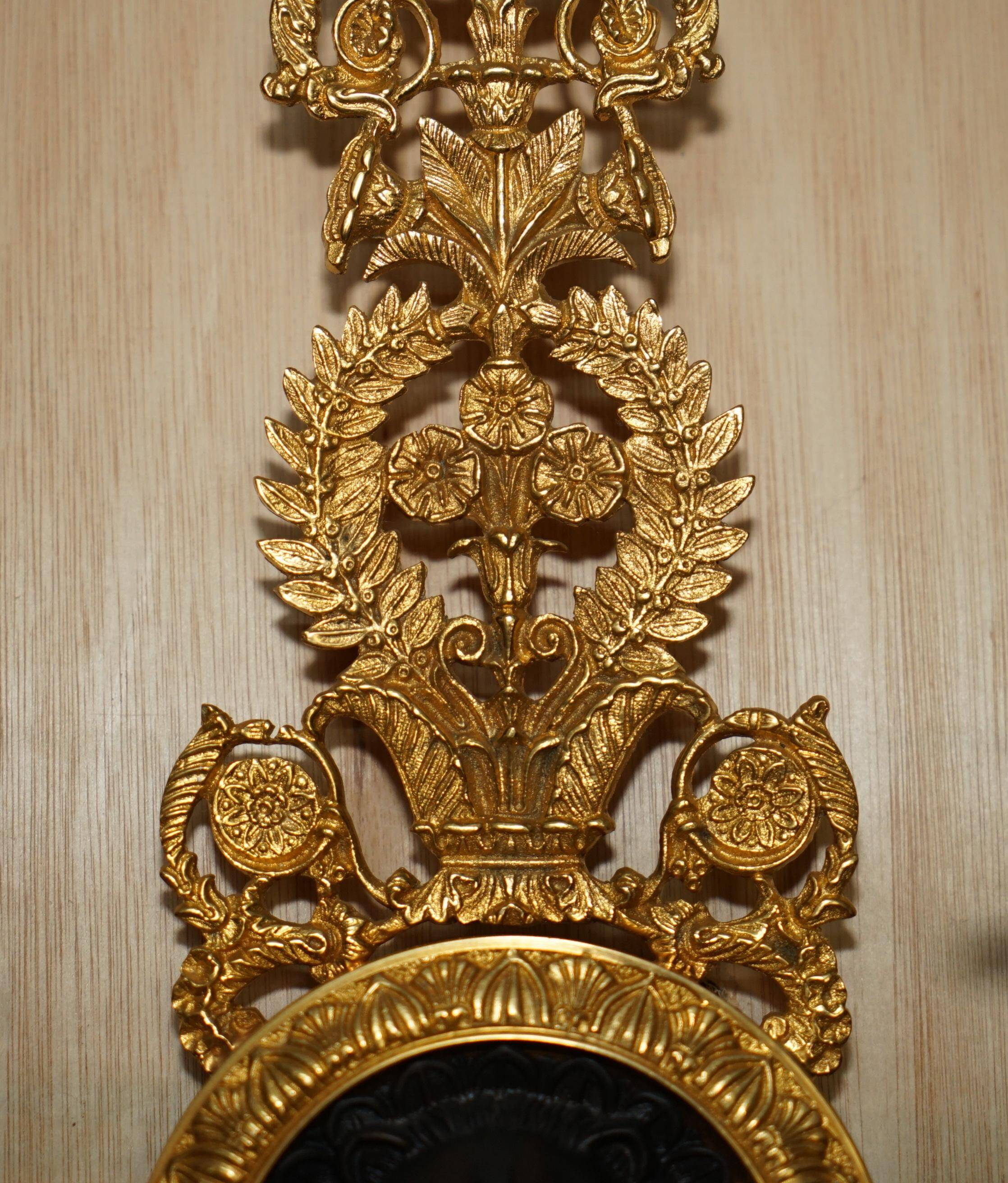 Pair of L'Originale wall sconces plated with 24-carat gold featuring four bronze candles.