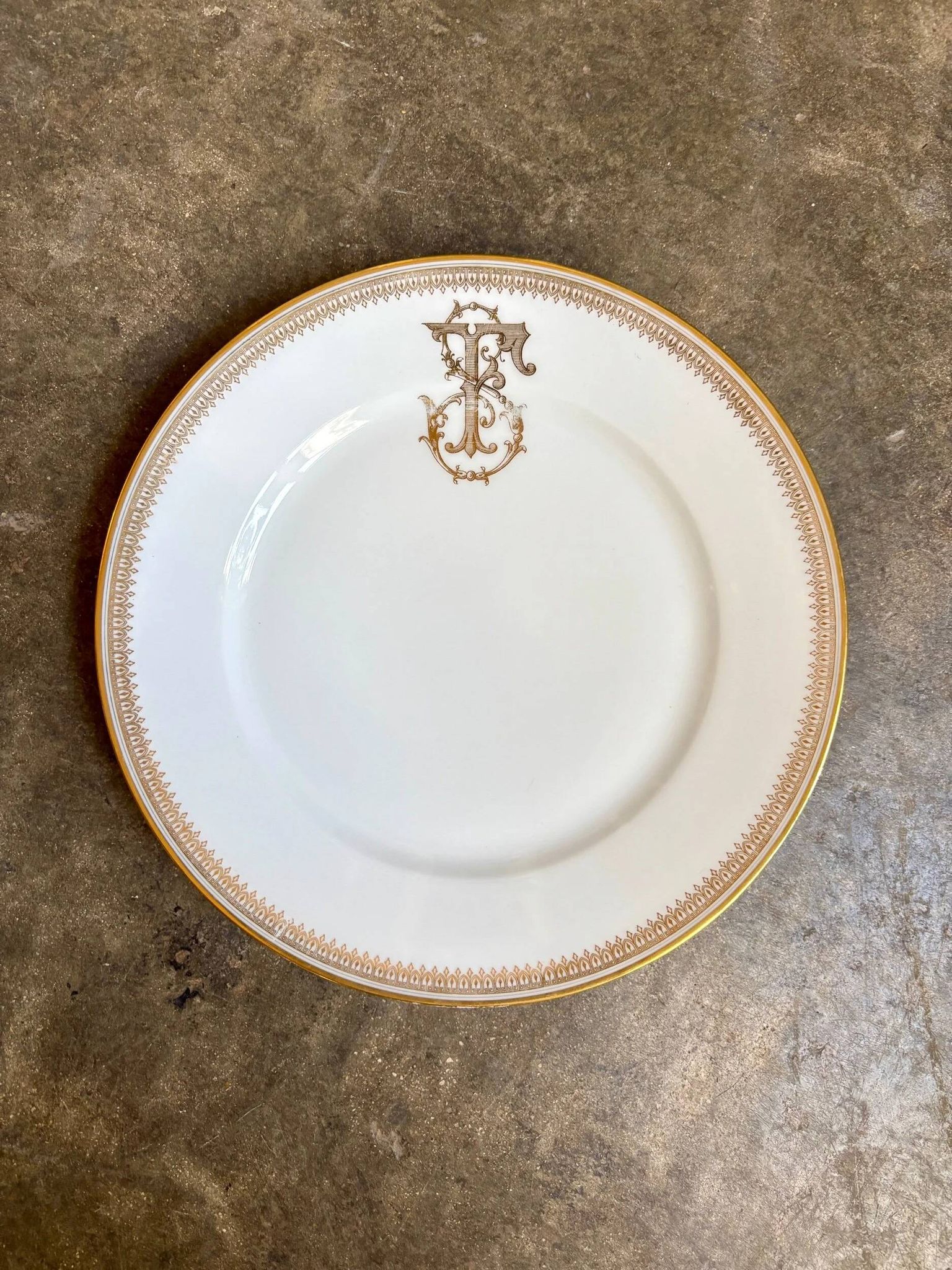 Assiette plate en porcelaine dorée monogrammée "F"