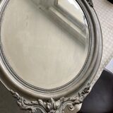 Beveled oval mirror in wood and stucco