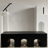 Black solid monoxyl wood bench carved into 3 arches