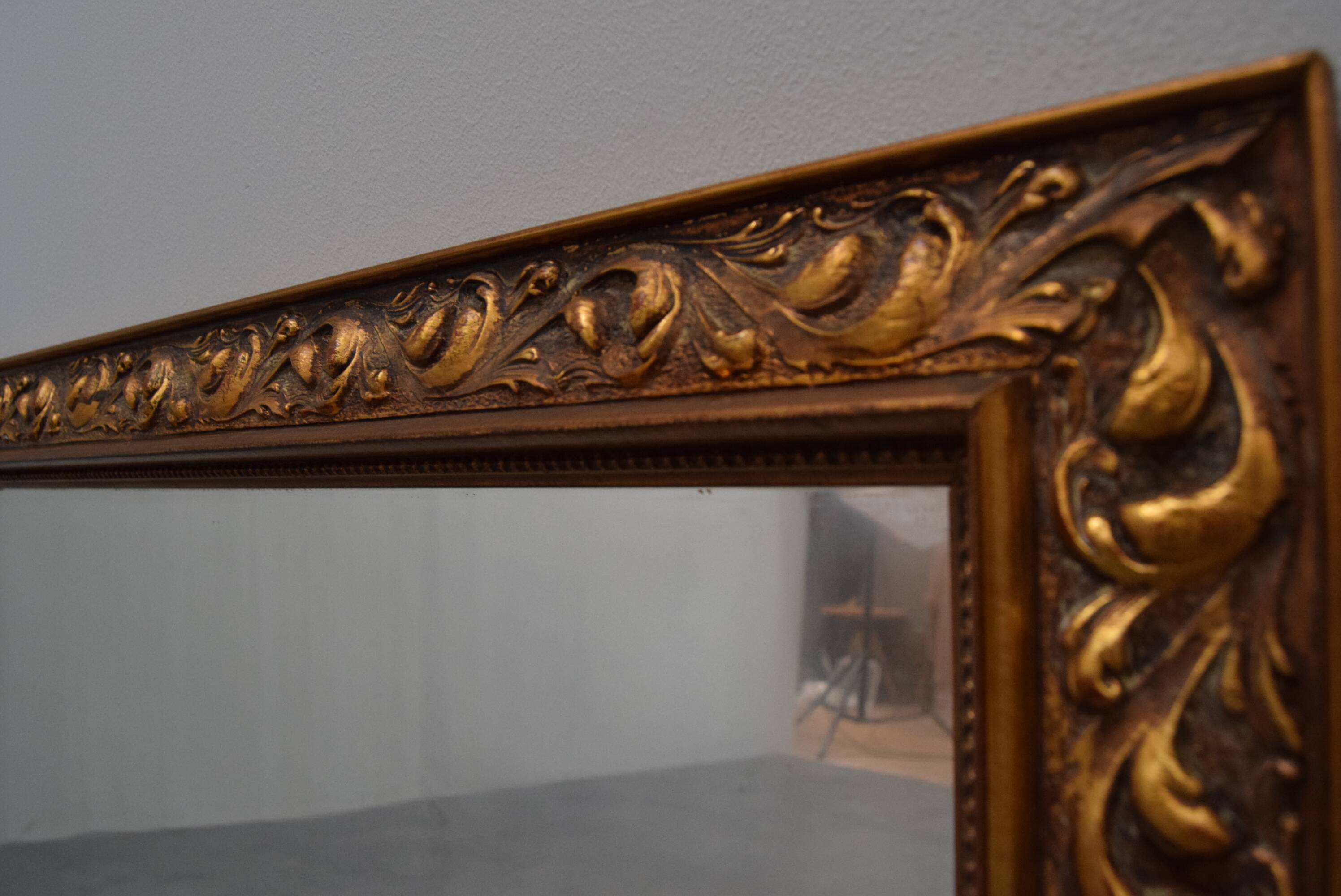 wall mirror in a decorative wooden frame.