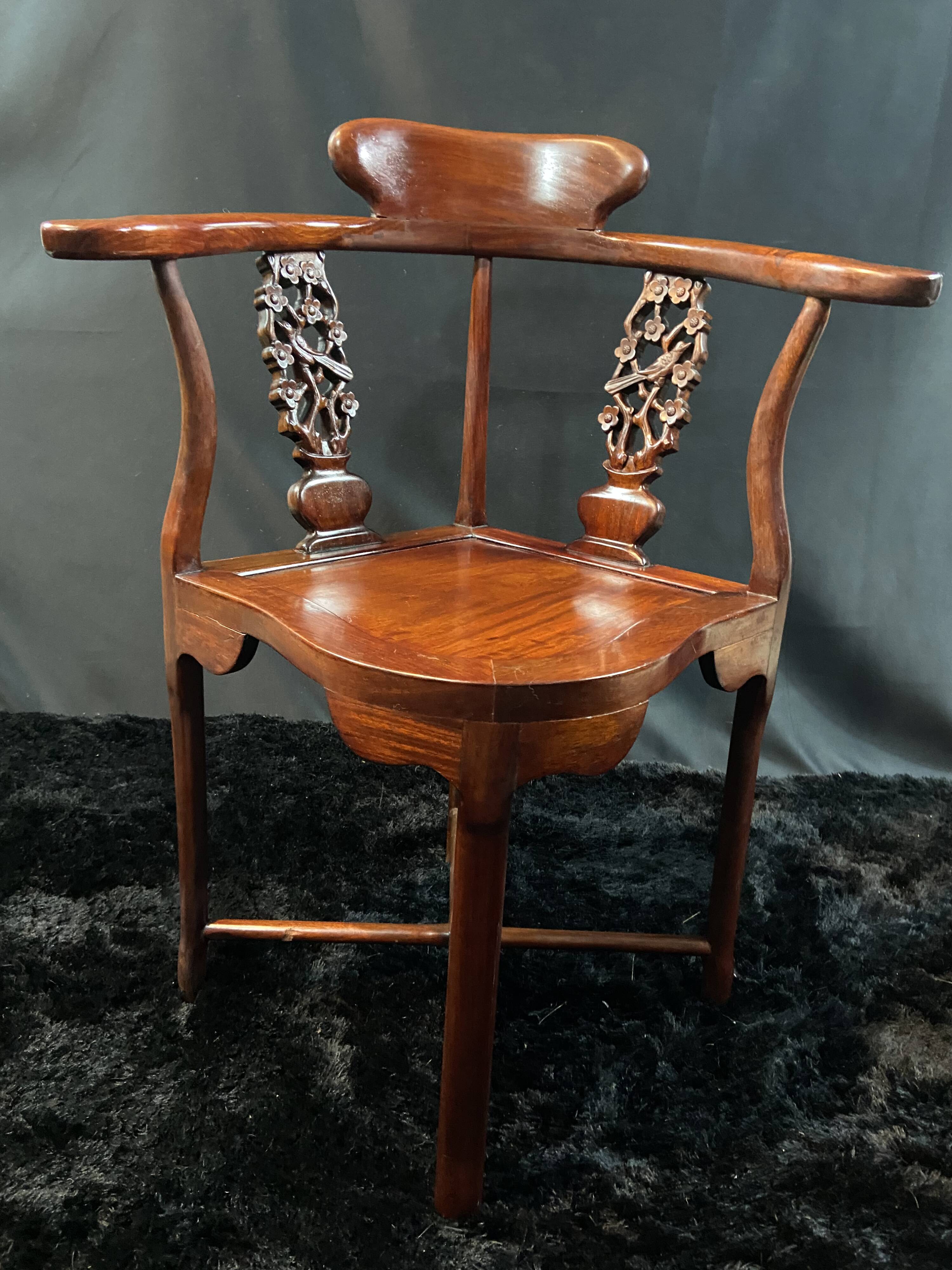 Corner armchair in solid wood with carved floral decoration featuring a bird.
