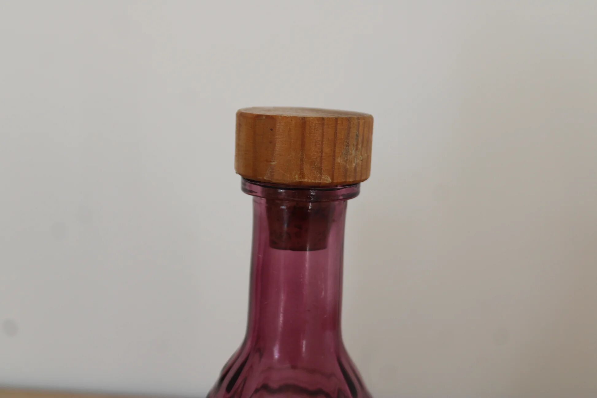 Vintage pink pressed glass carafe – retro decorative bottle with wooden stopper.