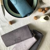 Set of four old damasked and monogrammed towels, tinted multiple colors
