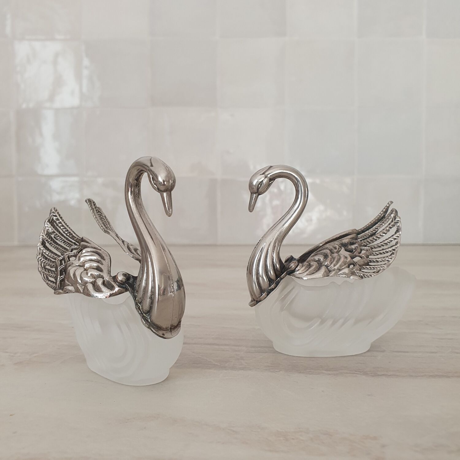 Two frosted glass swan salt cellars with silver plating.