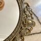 Oval mirror in gilded brass
