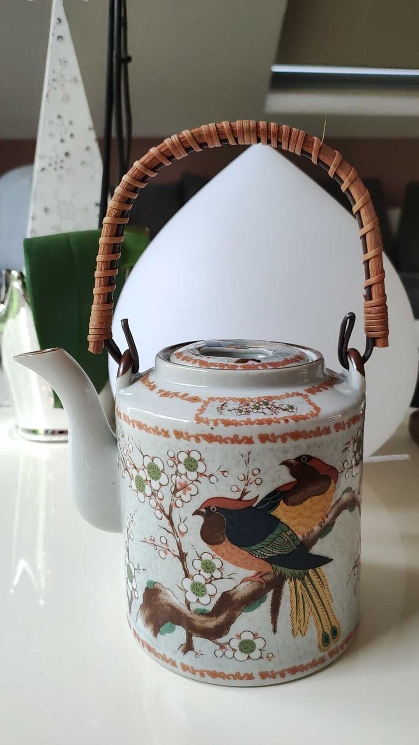 Japanese ceramic teapot. bird/paradise motifs/cherry trees. bamboo/rattan braided handle