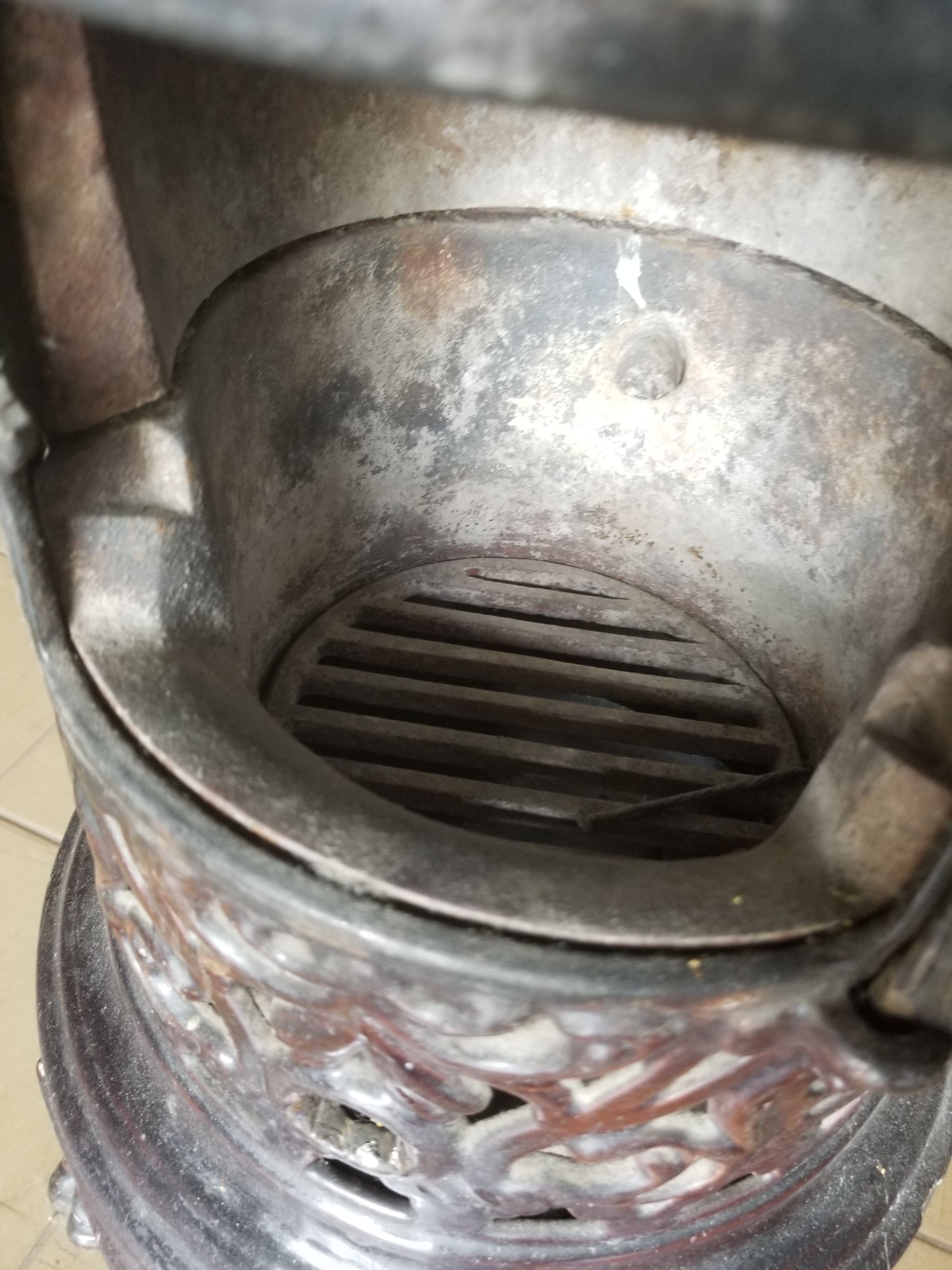 Old compact wood stove in enamelled cast iron with tripod feet with Lion's legs